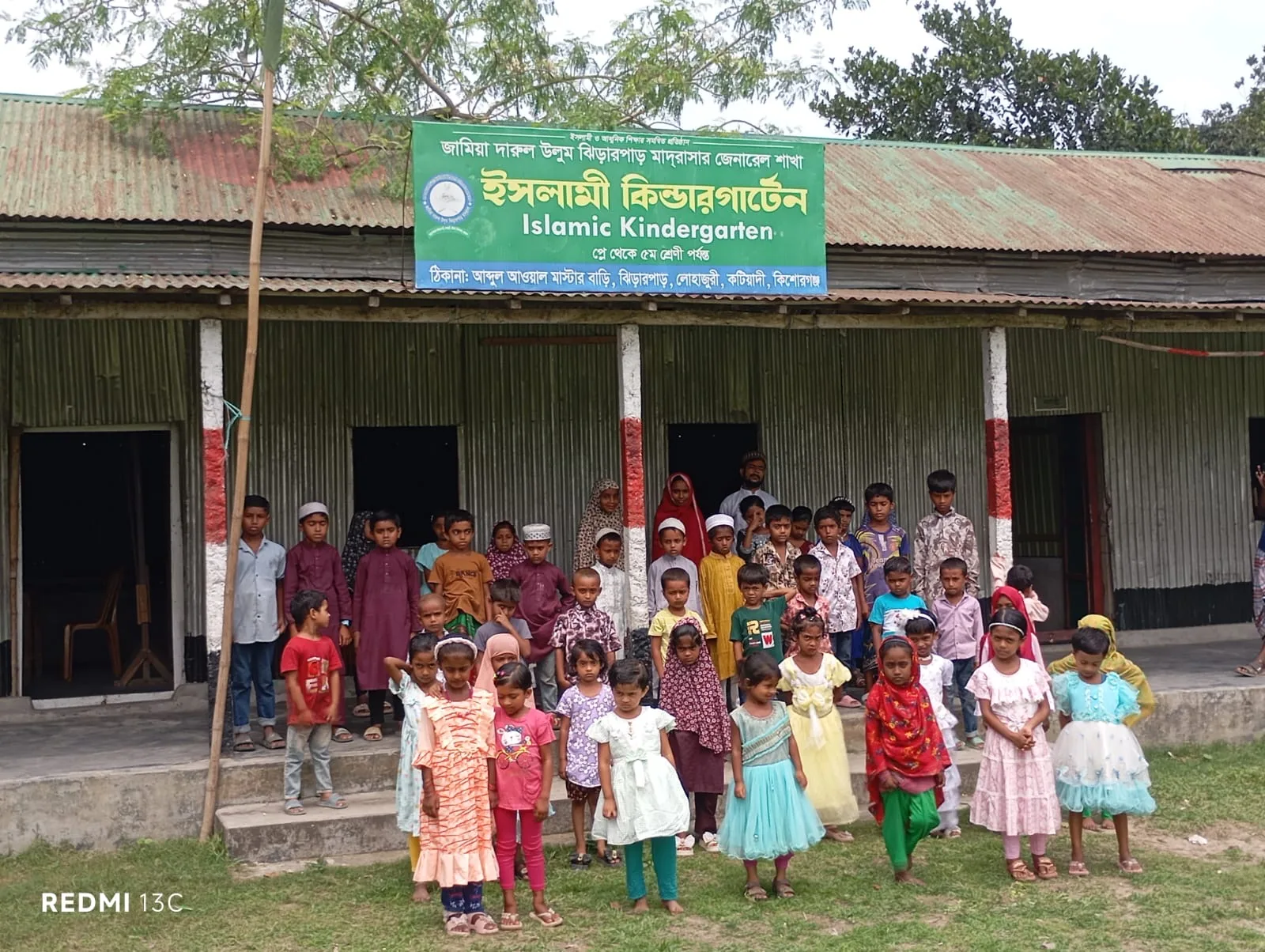 Children gathered in front of the existing tin-shed Islamic Kindergarten building