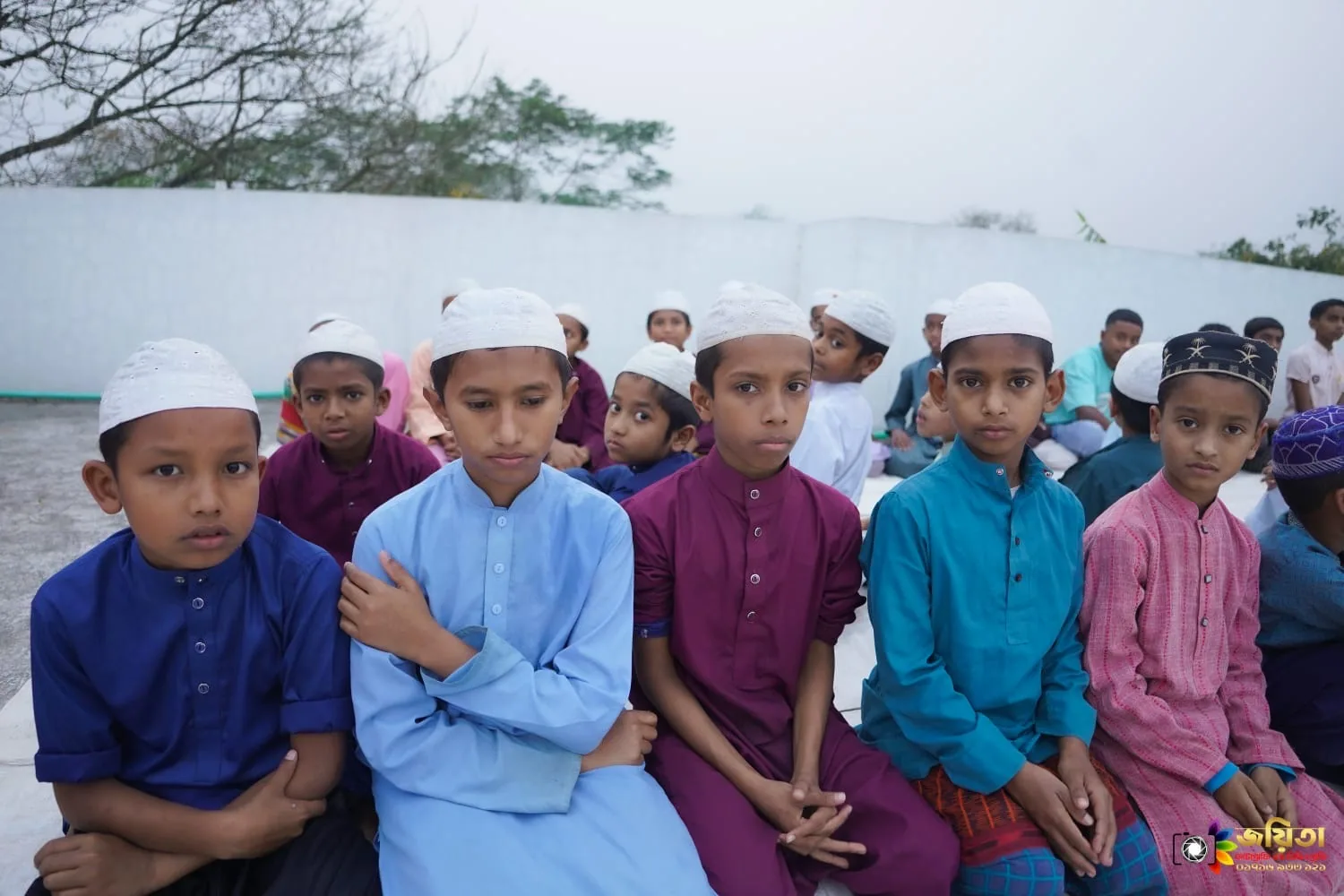 A group of orphan boys sitting together at the campus